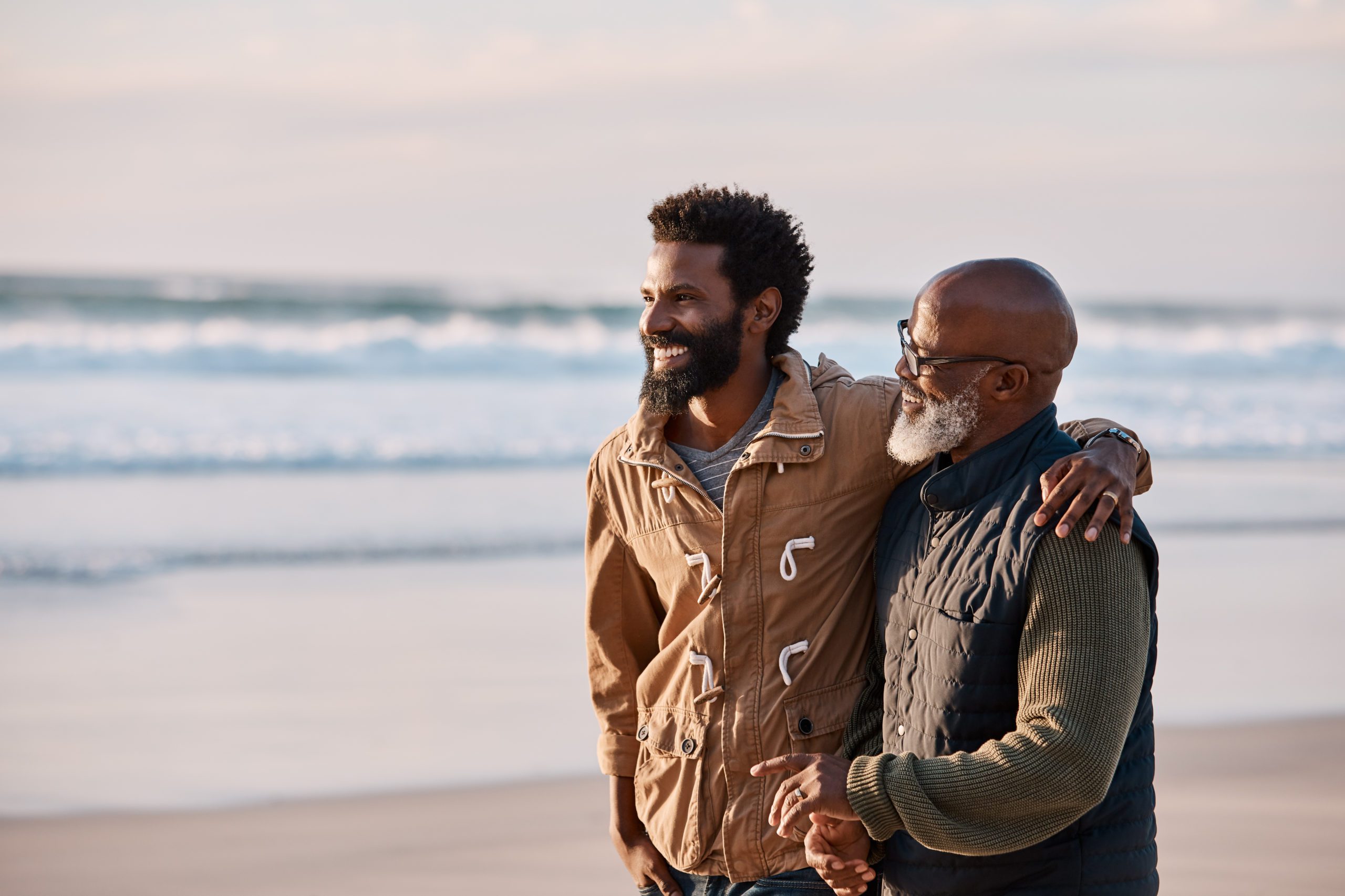 Dad and his son or heir walking on beach