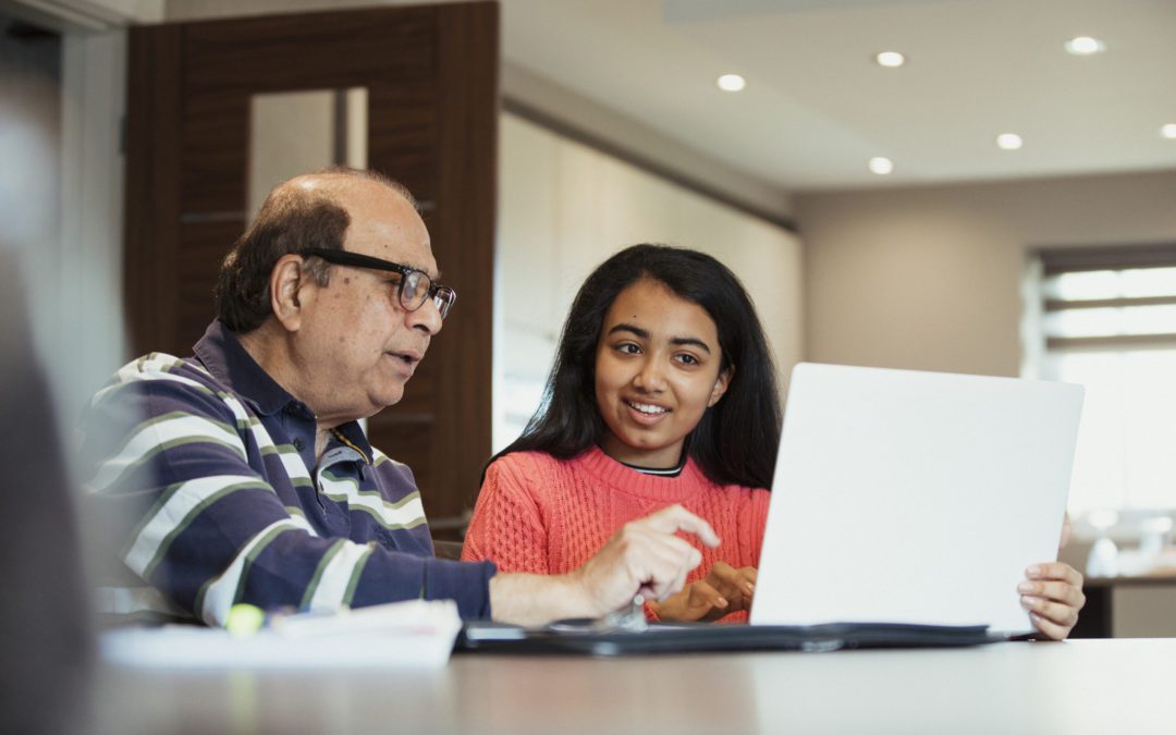 Grandparent showing grandchild their Roth IRA on computer