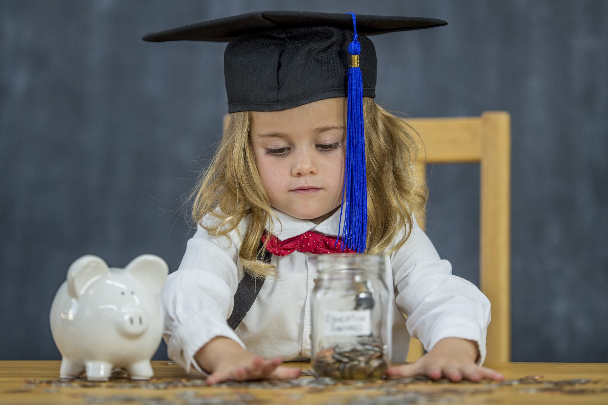 Child saving money in piggy bank to add to their 529 plan to save for college