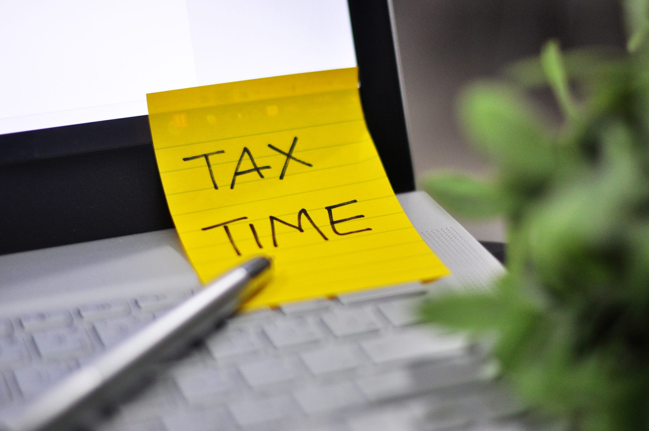 Sticky note on computer saying tax time as a reminder to look for last-minute tax planning tips for 2022