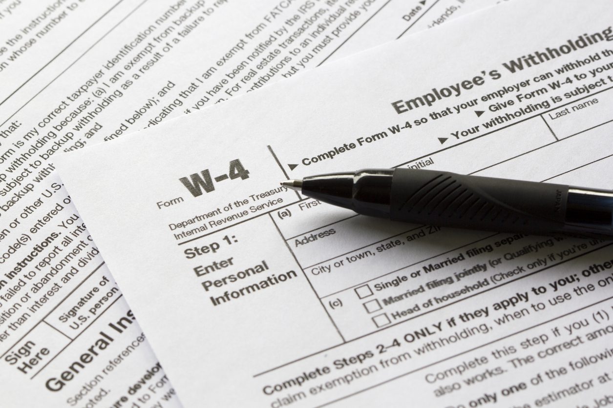 Upper left corner of a Form W-4 with a black pen laying on the form