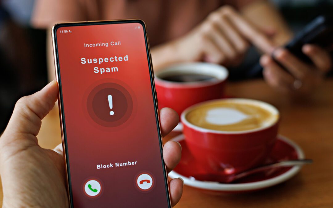 Spam call appearing on phone screen while two people enjoy coffee.