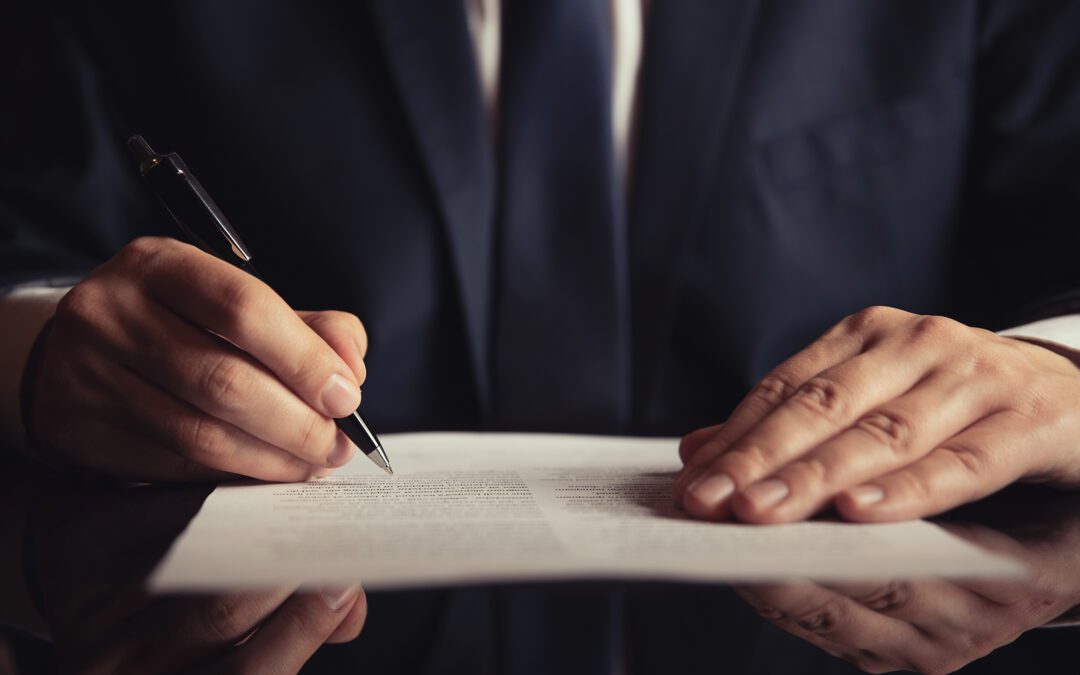 Man in suit signing legal document representing a revocable trust or irrevocable trust