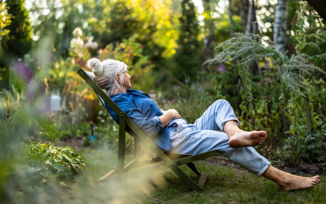 Mature woman relaxing in deckchair in her garden