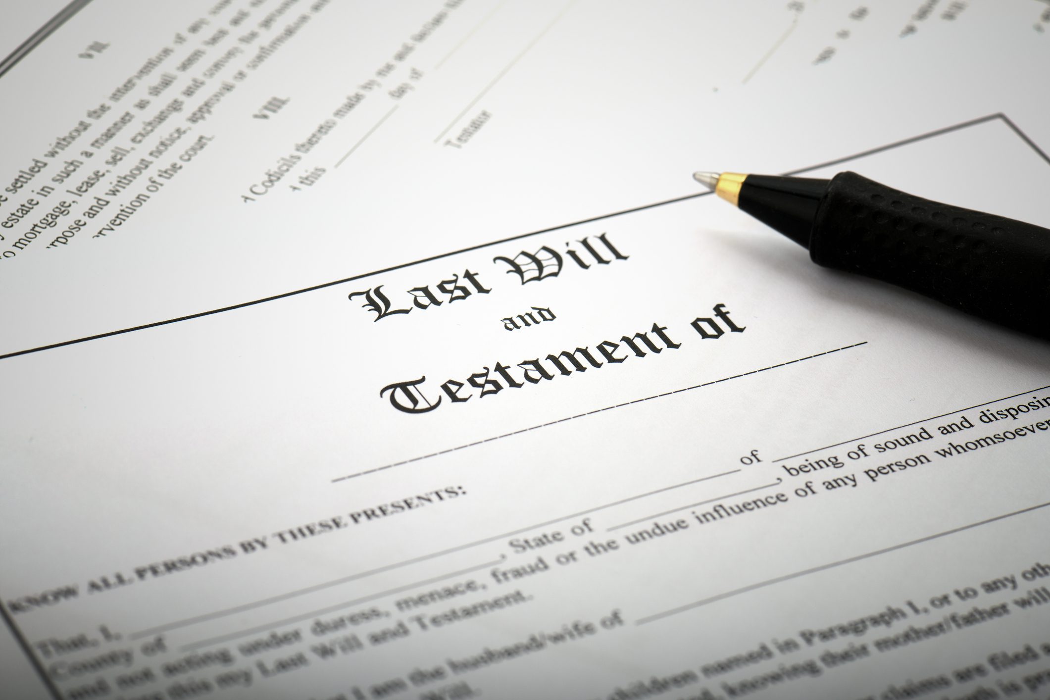 Image of will document with pen representing topic of when you should create a will or trust